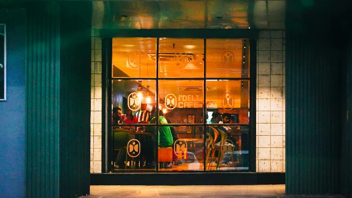 Warmly lit storefront with reflections in the glass.